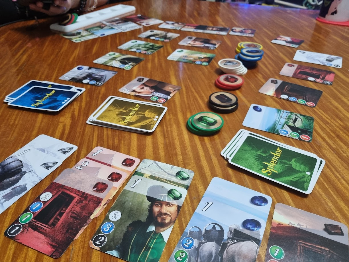 Gameplay photo of the board game Splendor featuring various components and board state.