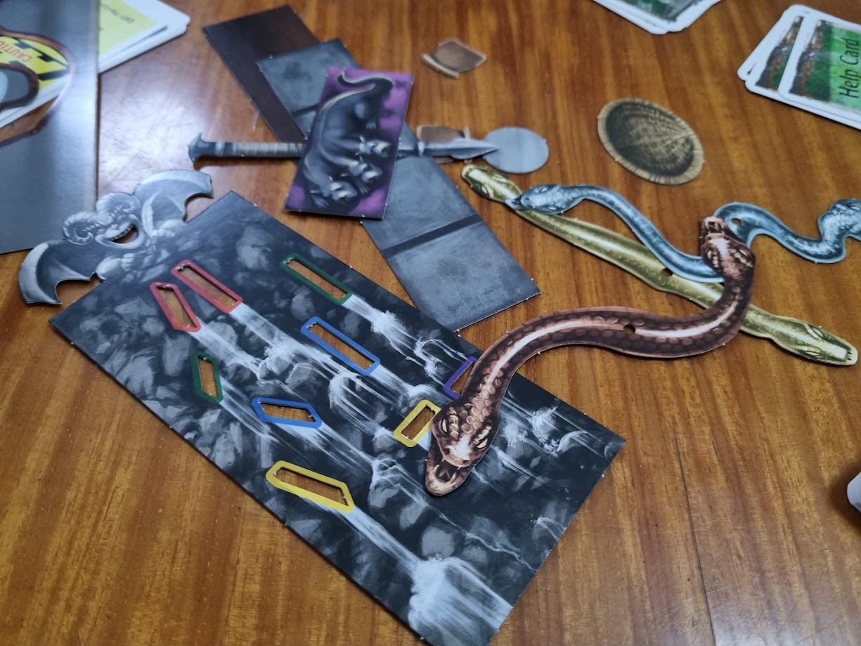 Gameplay photo of the board game EXIT: The Game – The Cursed Labyrinth featuring various components and board state.