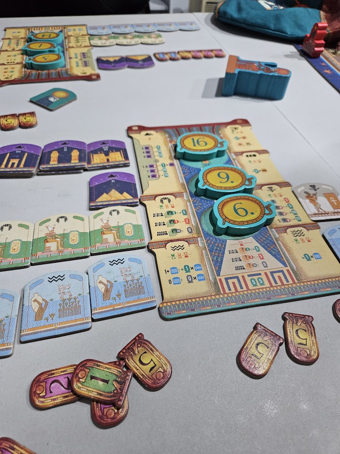 Gameplay photo of the board game Ra featuring various components and board state.