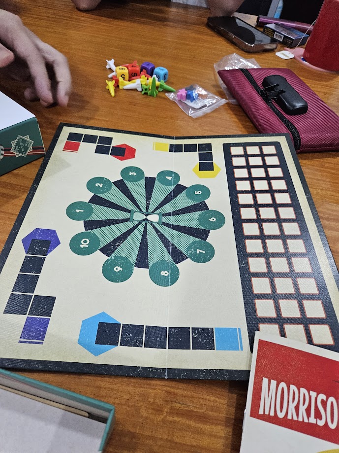 Gameplay photo of the board game The Morrison Game Factory featuring various components and board state.