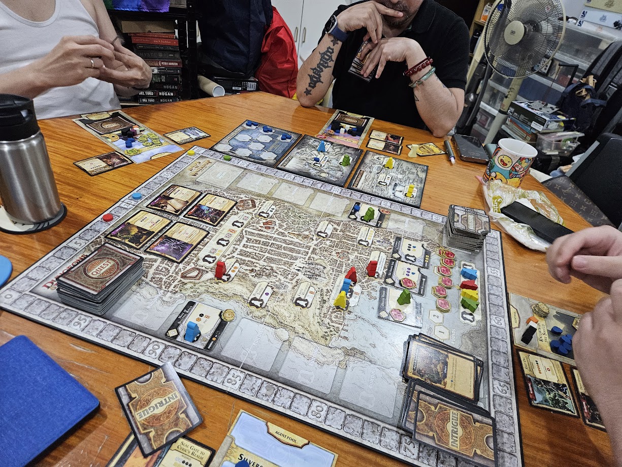 Gameplay photo of the board game Lords of Waterdeep: Scoundrels of Skullport featuring various components and board state.