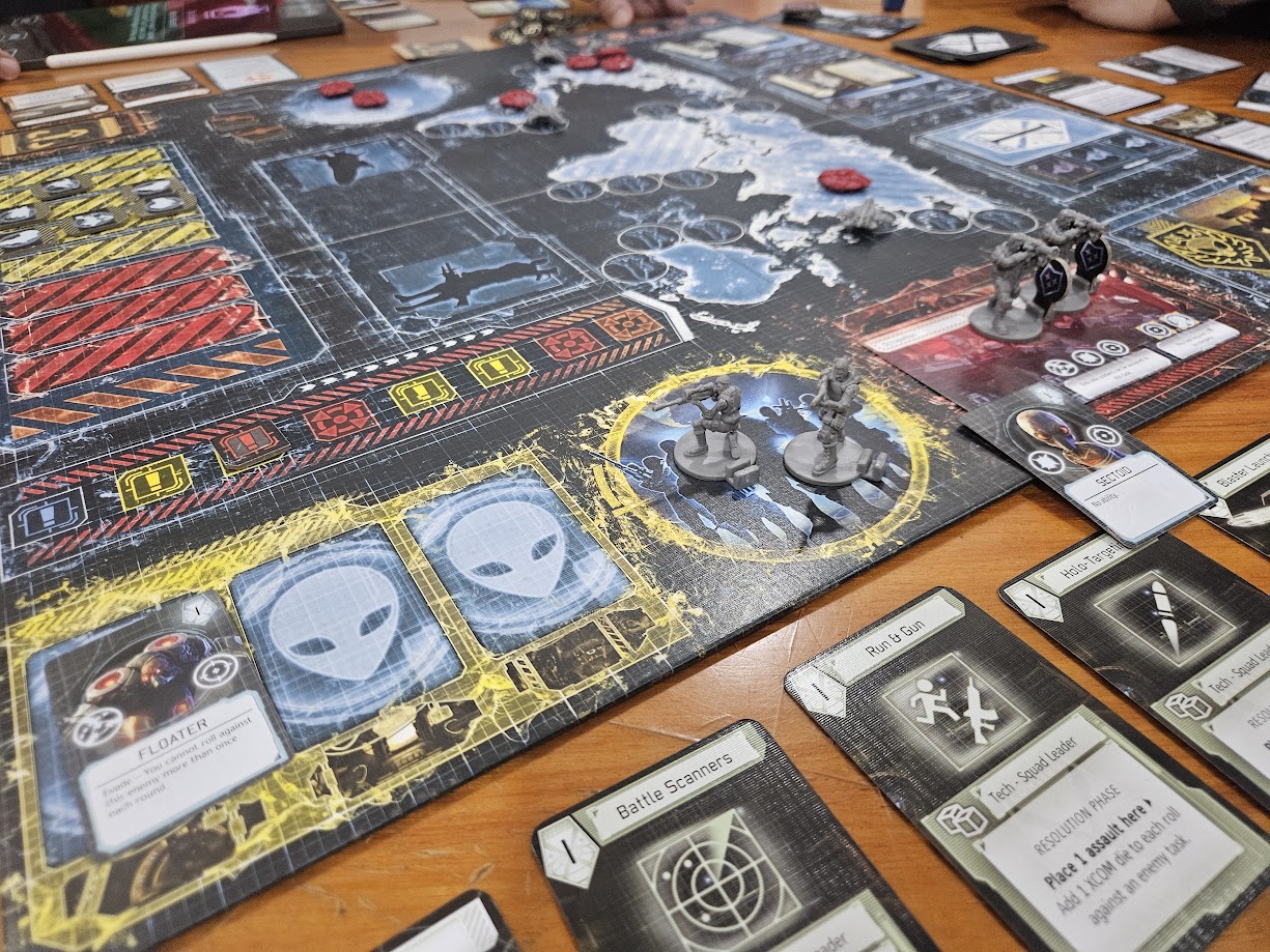 Gameplay photo of the board game XCOM: The Board Game featuring various components and board state.