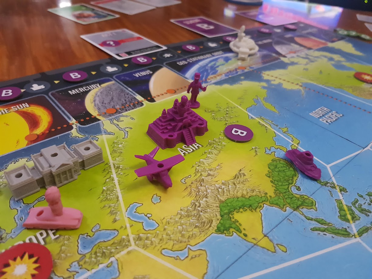 Gameplay photo of the board game Thunderbirds: The Hood featuring various components and board state.