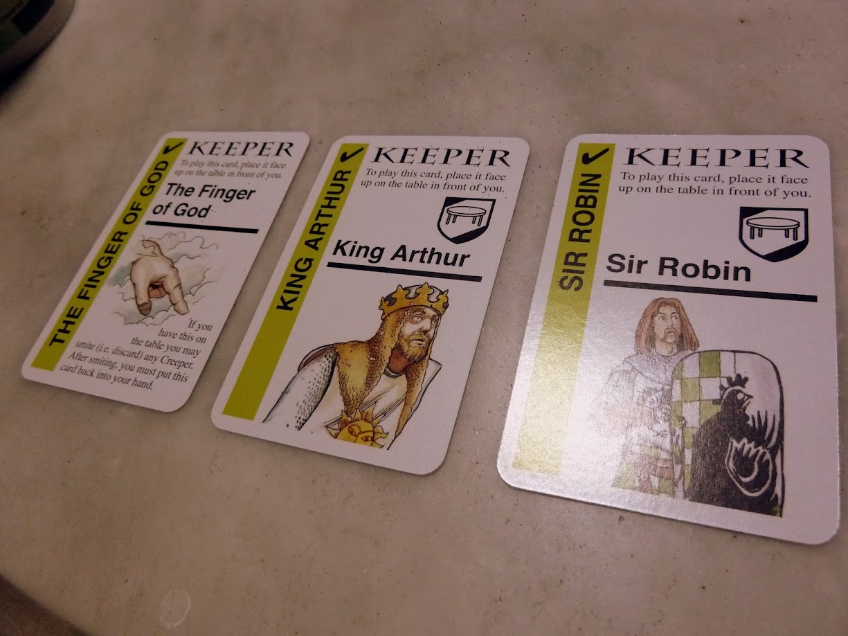 Gameplay photo of the board game Monty Python Fluxx featuring various components and board state.