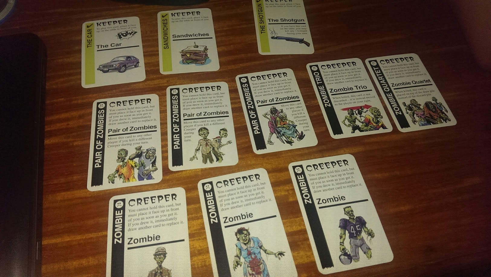 Gameplay photo of the board game Zombie Fluxx featuring various components and board state.