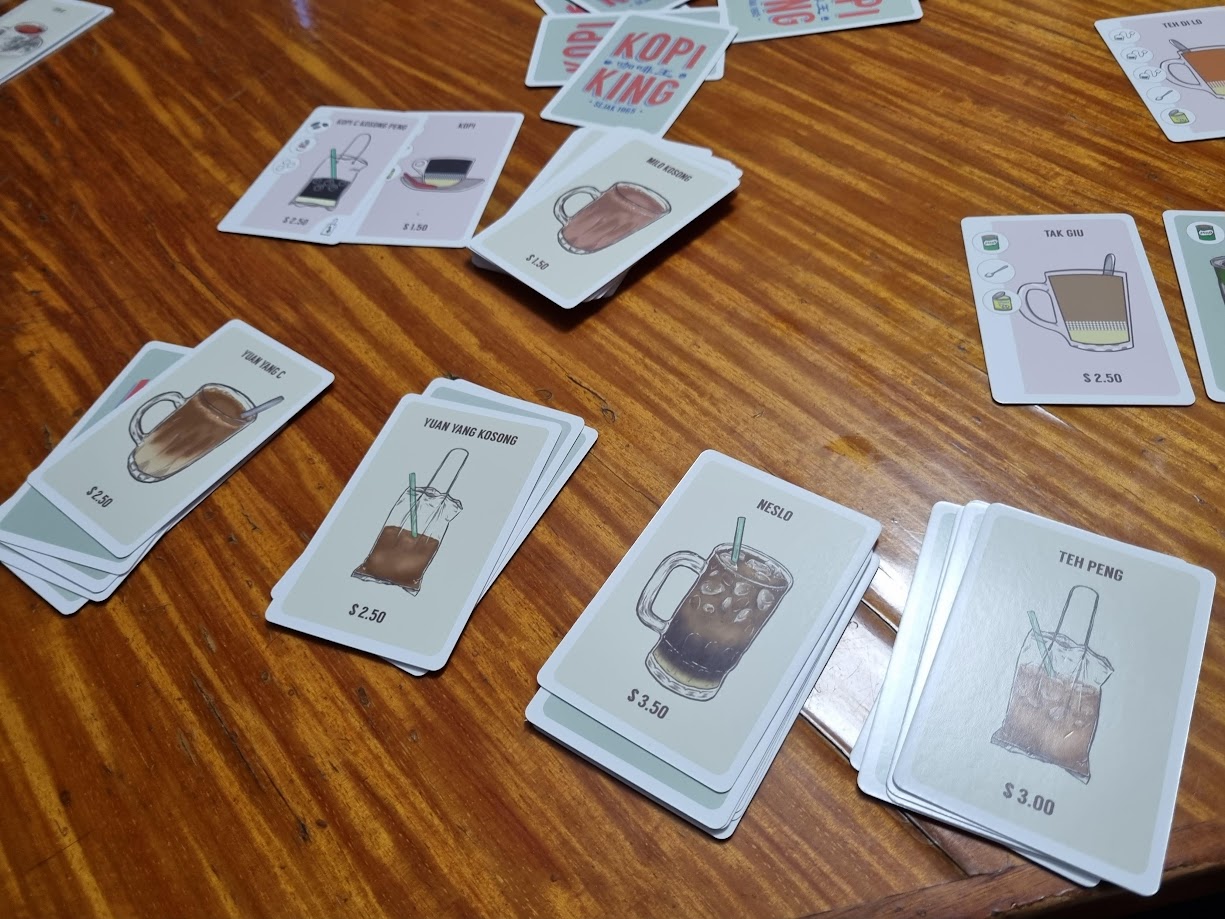 Gameplay photo of the board game Kopi King featuring various components and board state.
