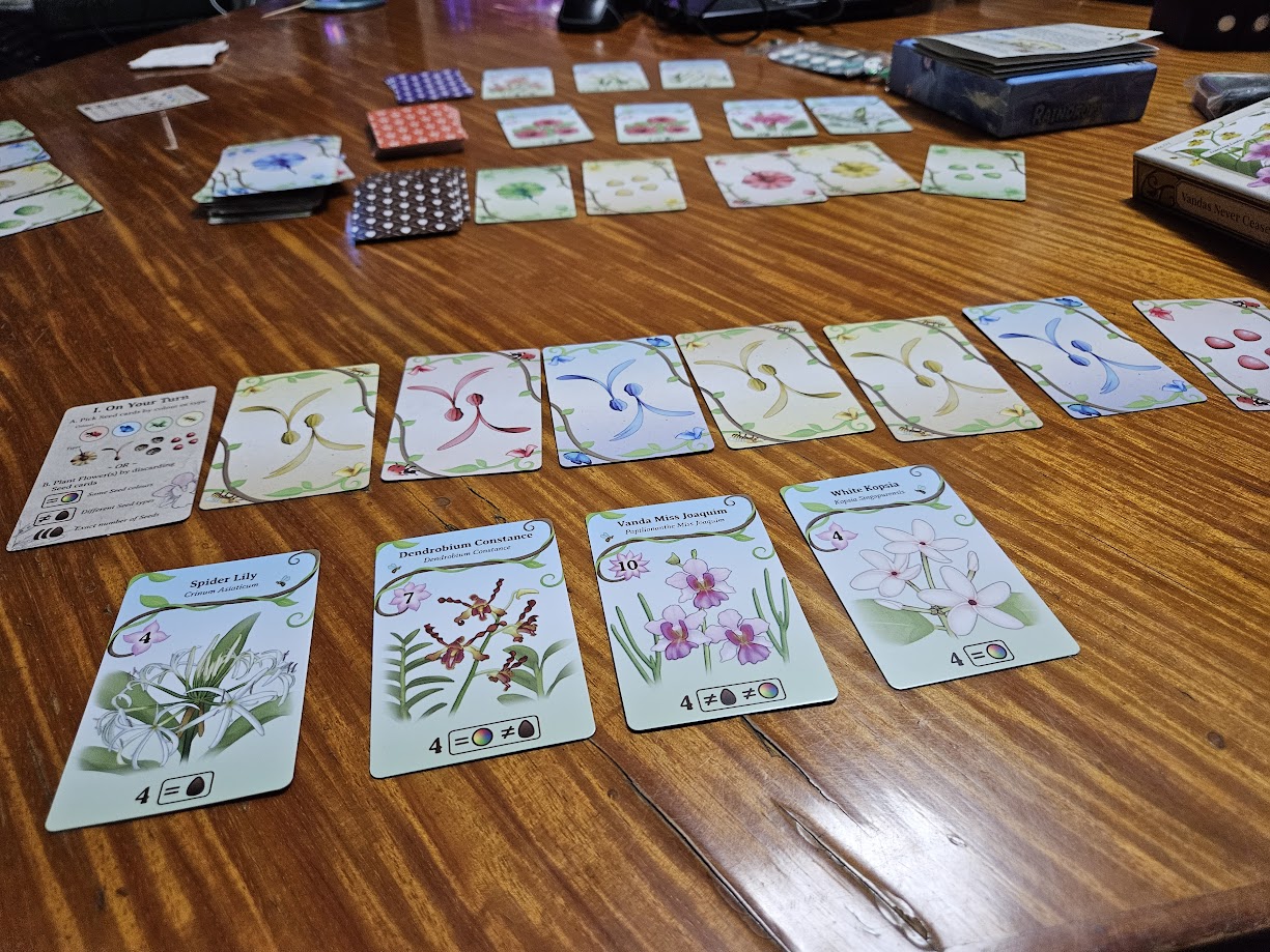 Gameplay photo of the board game Oh My. Orchids! featuring various components and board state.