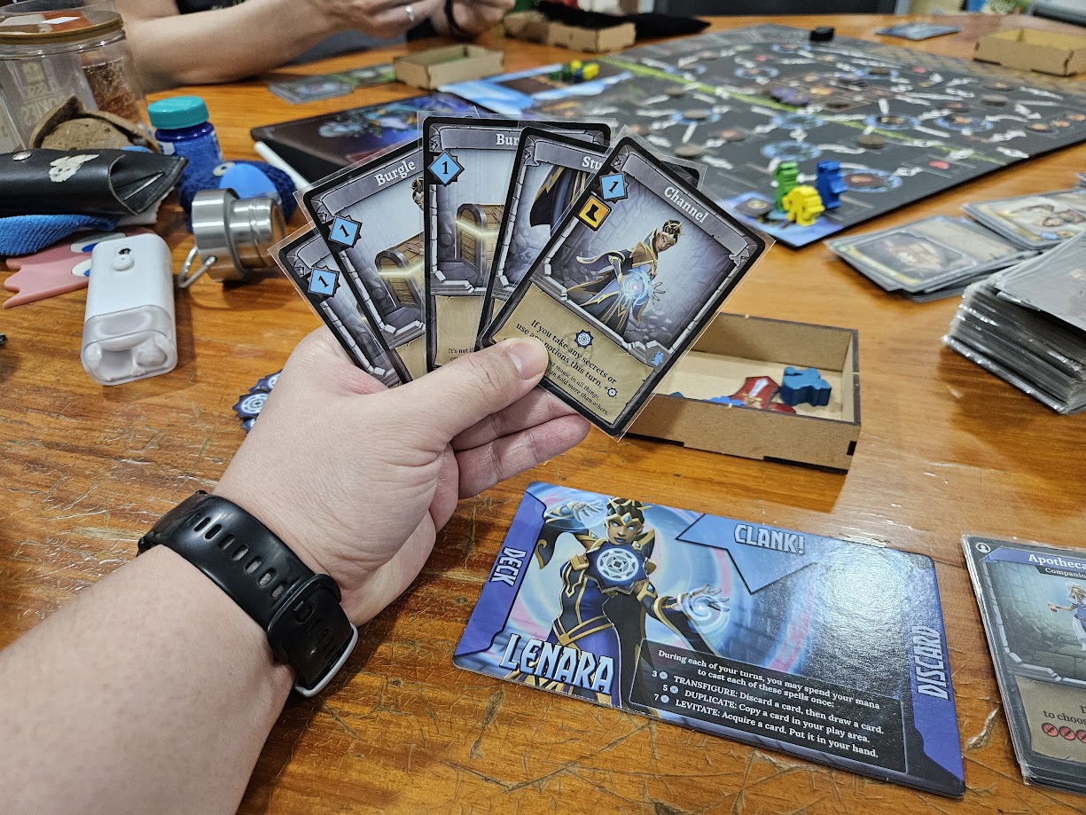 Gameplay photo of the board game Clank!: Adventuring Party featuring various components and board state.