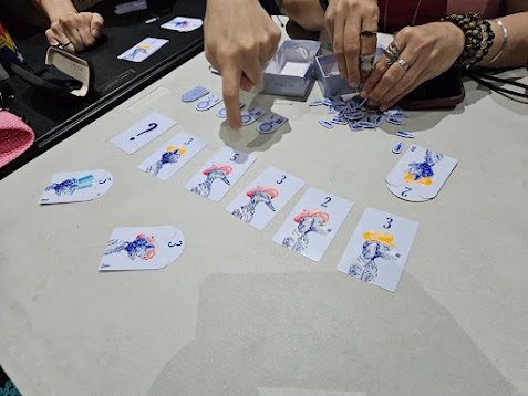 Gameplay photo of the board game Petiquette featuring various components and board state.