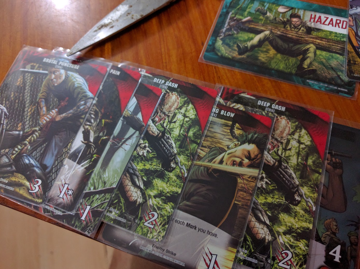 Gameplay photo of the board game Legendary Encounters: A Predator Deck Building Game featuring various components and board state.