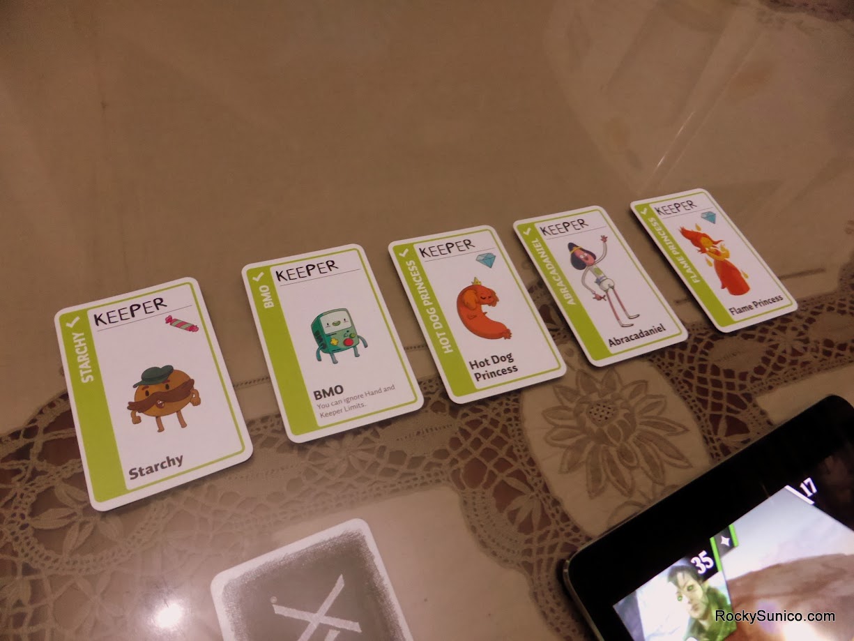Gameplay photo of the board game Adventure Time Fluxx featuring various components and board state.