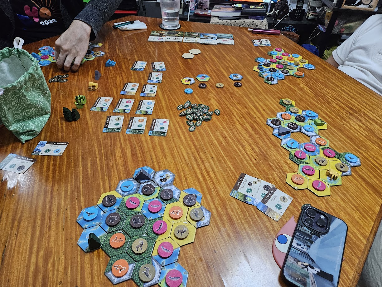 Gameplay photo of the board game Cascadia: Landmarks featuring various components and board state.