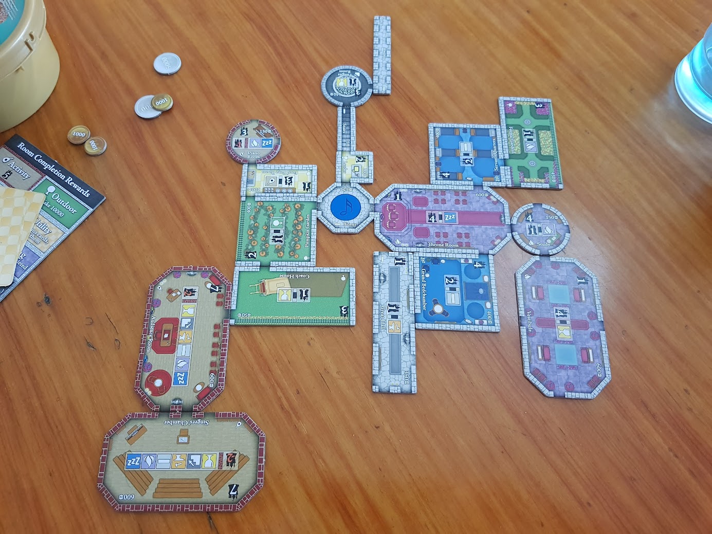 Gameplay photo of the board game Castles of Mad King Ludwig featuring various components and board state.