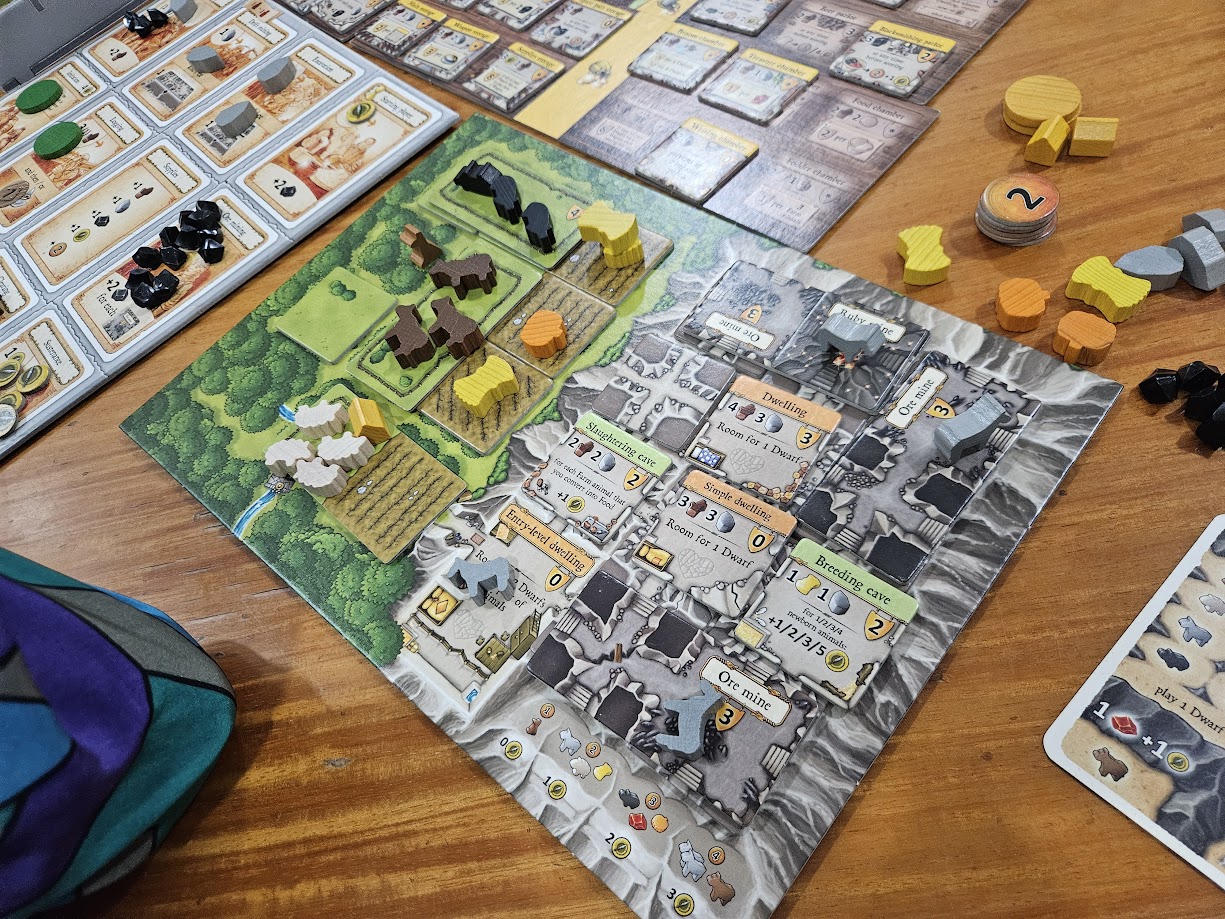 Gameplay photo of the board game Caverna: The Cave Farmers featuring various components and board state.