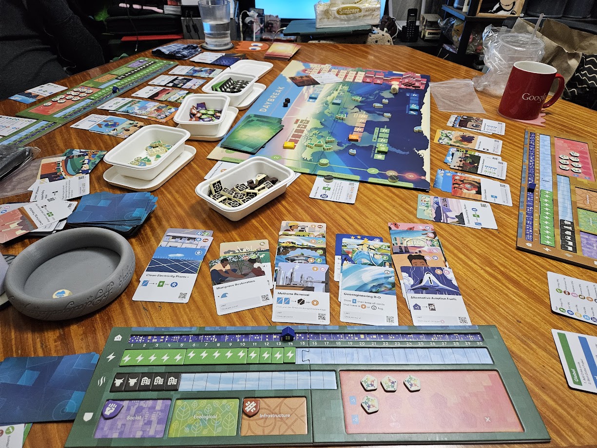 Gameplay photo of the board game Daybreak featuring various components and board state.
