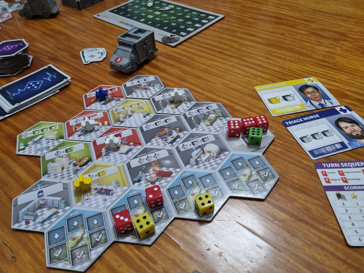 Gameplay photo of the board game Dice Hospital featuring various components and board state.