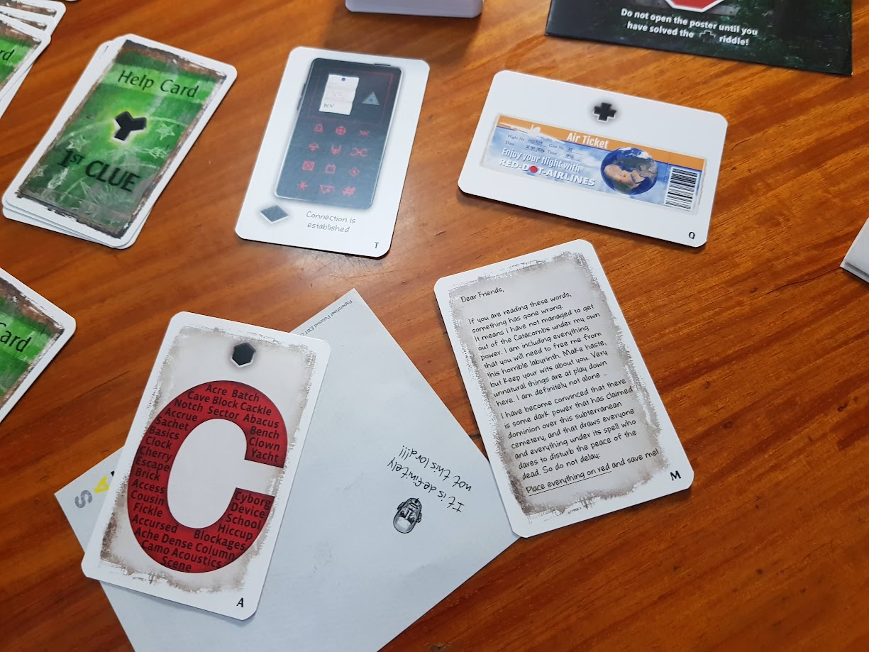 Gameplay photo of the board game EXIT: The Game – The Catacombs of Horror featuring various components and board state.