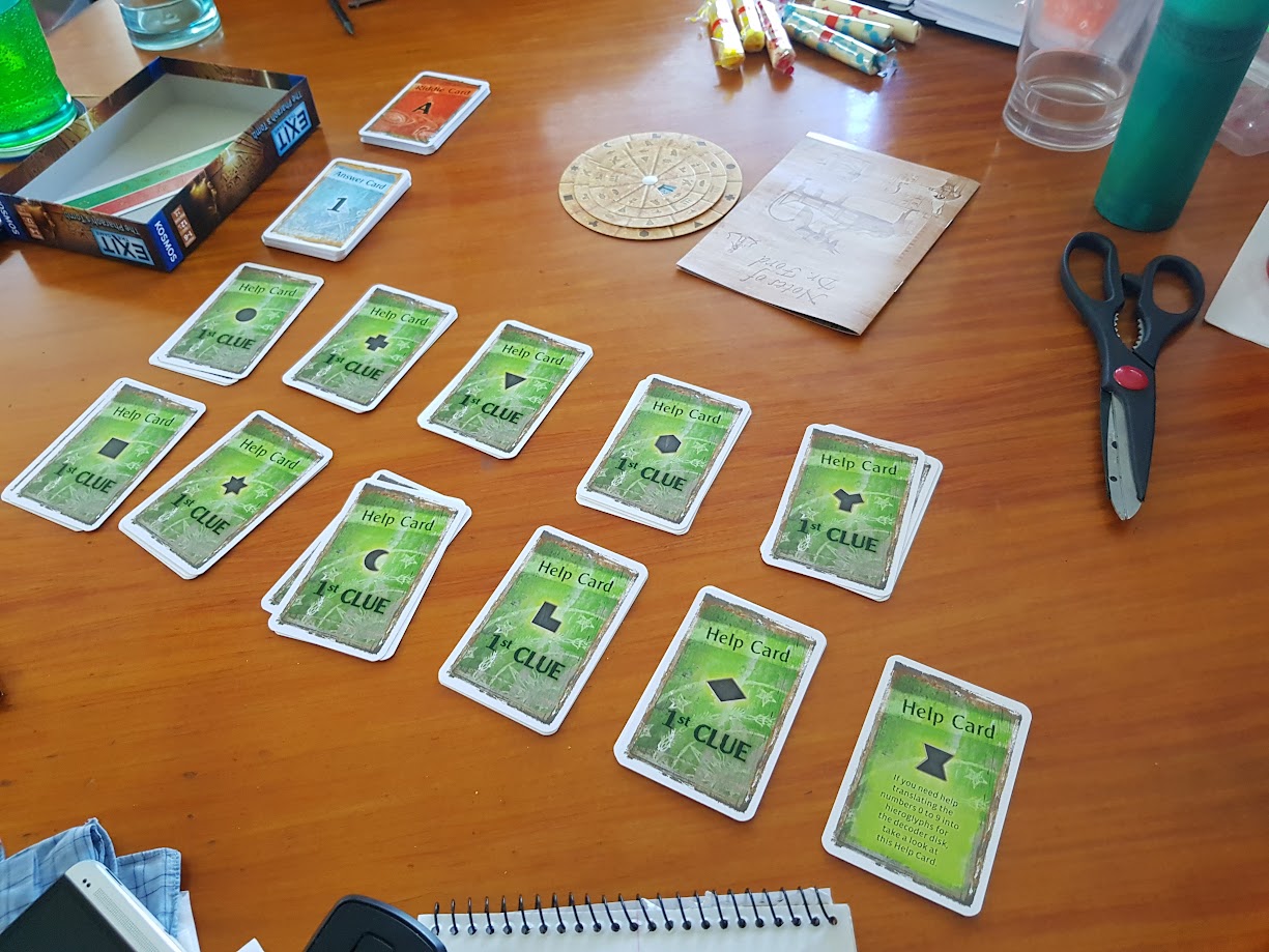 Gameplay photo of the board game EXIT: The Game – The Pharaoh's Tomb featuring various components and board state.