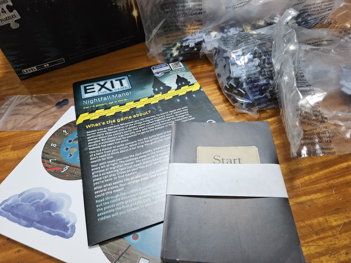 Gameplay photo of the board game EXIT: The Game + Puzzle – Nightfall Manor featuring various components and board state.
