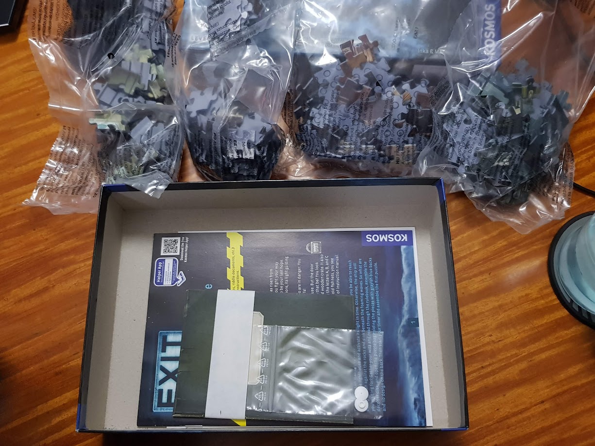 Gameplay photo of the board game EXIT: The Game + Puzzle – The Deserted Lighthouse featuring various components and board state.