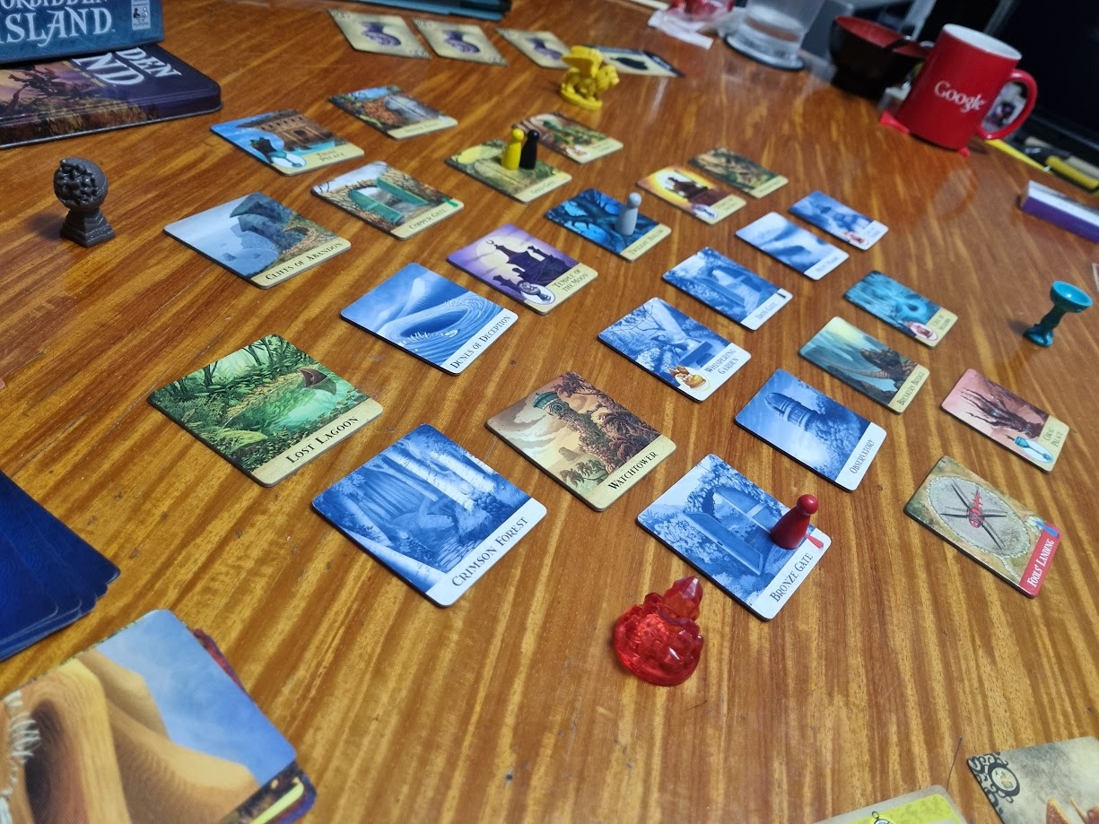 Gameplay photo of the board game Forbidden Island featuring various components and board state.
