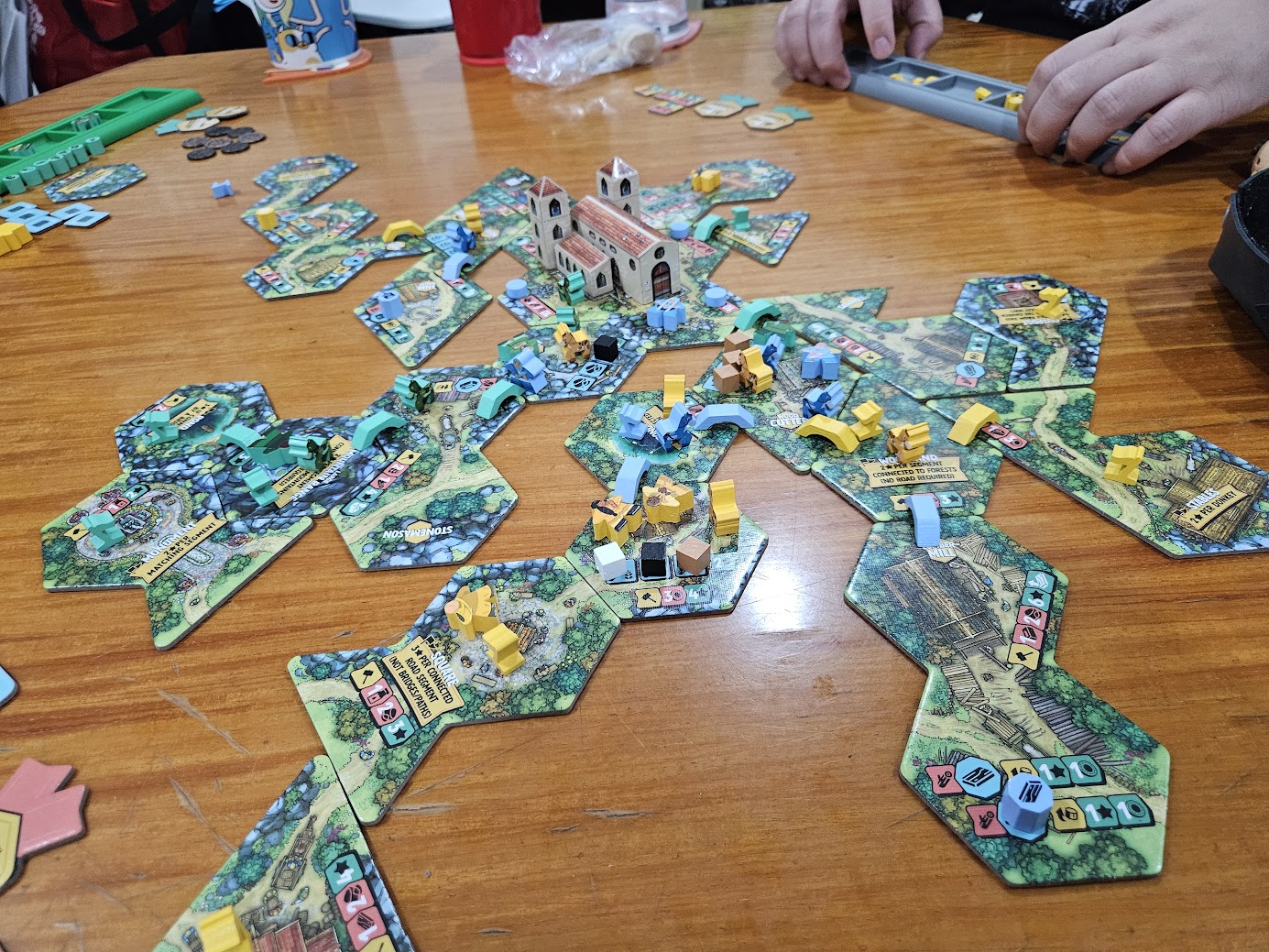 Gameplay photo of the board game Hamlet: The Village Building Game featuring various components and board state.