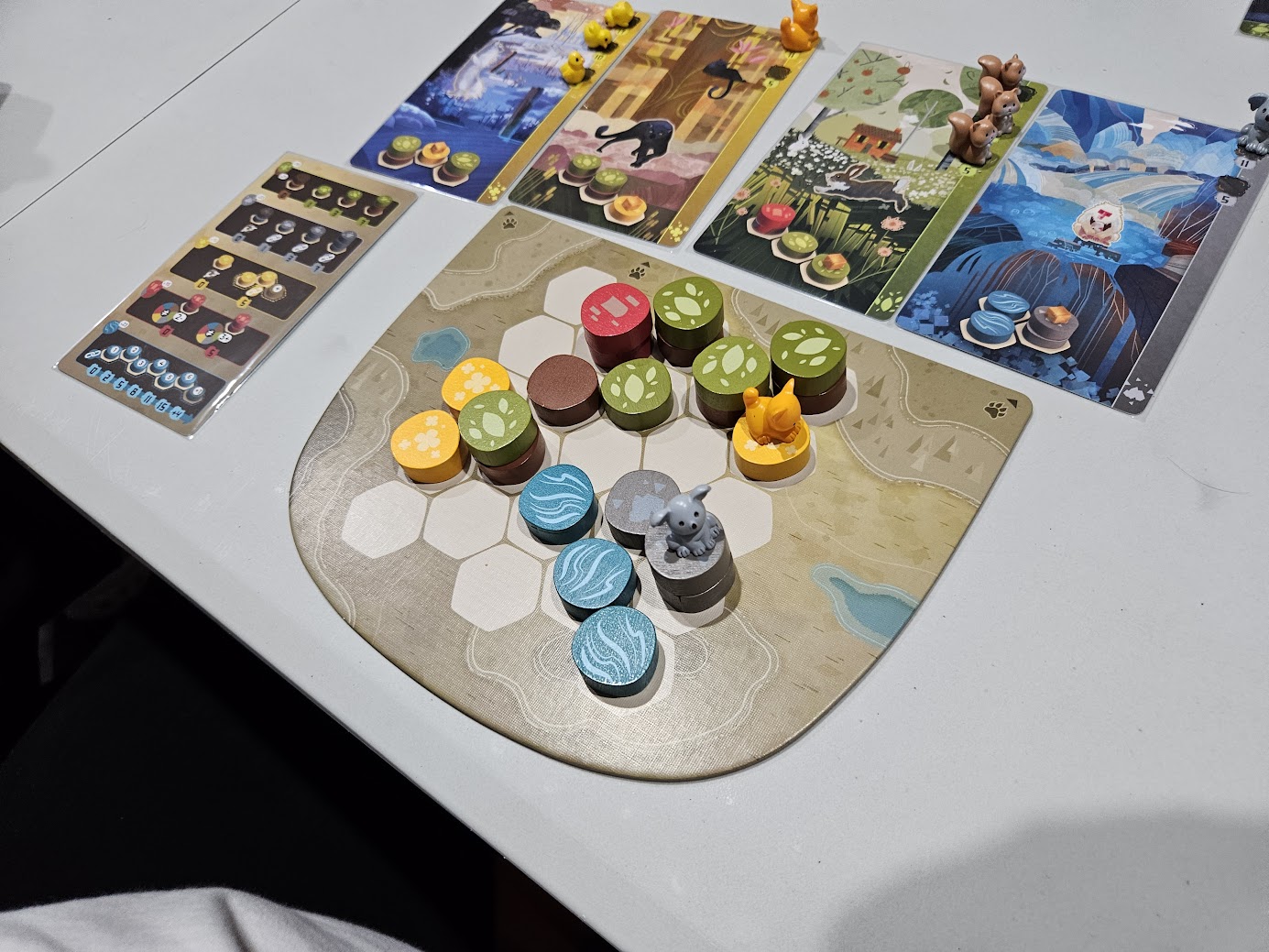 Gameplay photo of the board game Harmonies featuring various components and board state.