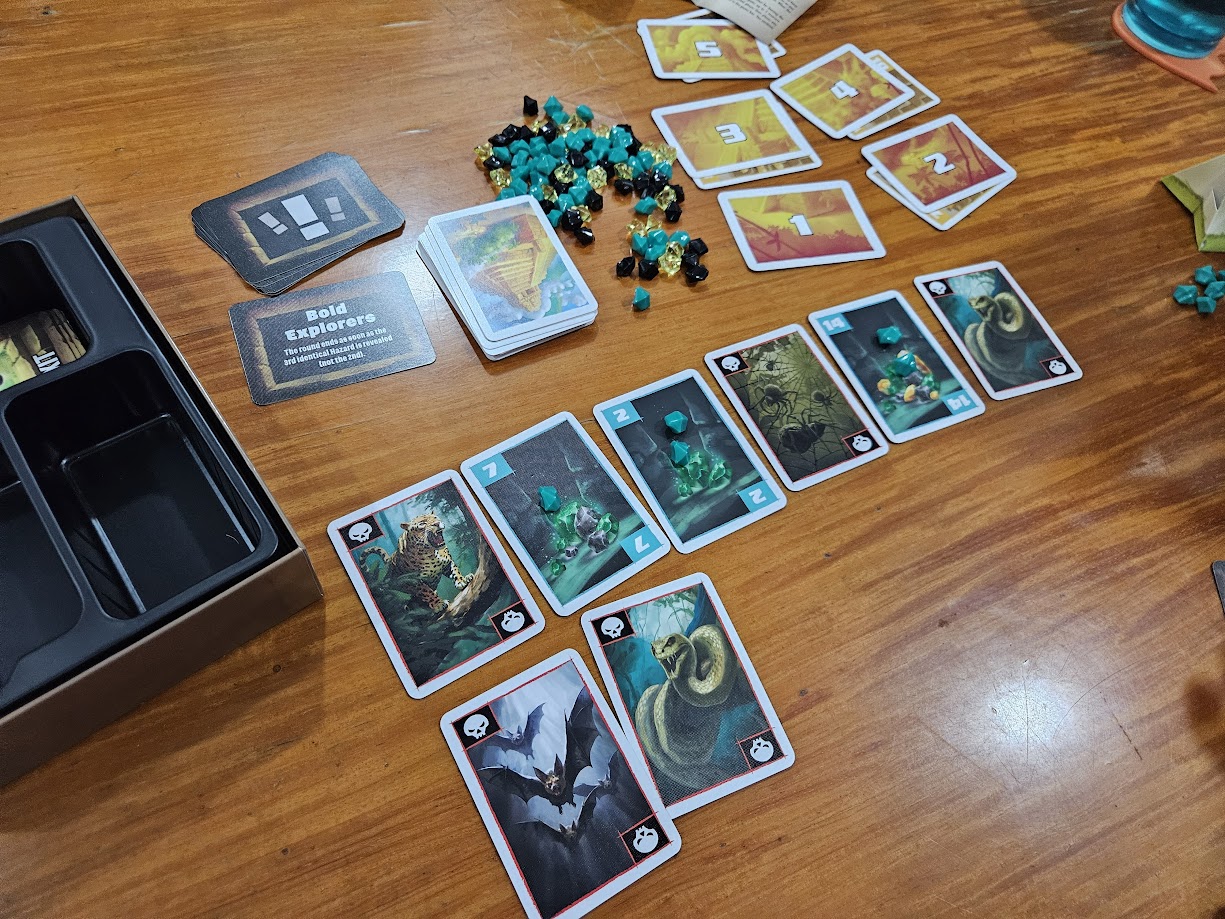 Gameplay photo of the board game Incan Gold featuring various components and board state.