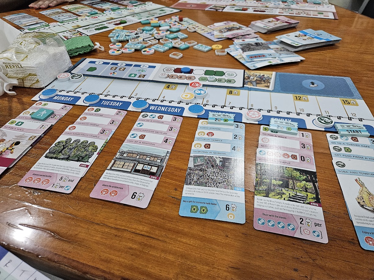 Gameplay photo of the board game Let's Go! To Japan featuring various components and board state.
