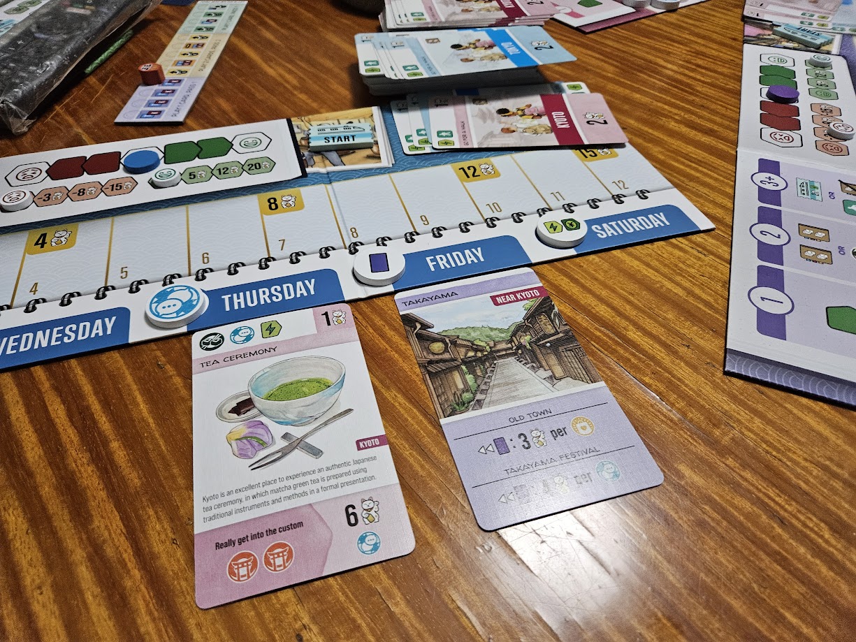 Gameplay photo of the board game Let's Go! To Japan: Day Trip featuring various components and board state.