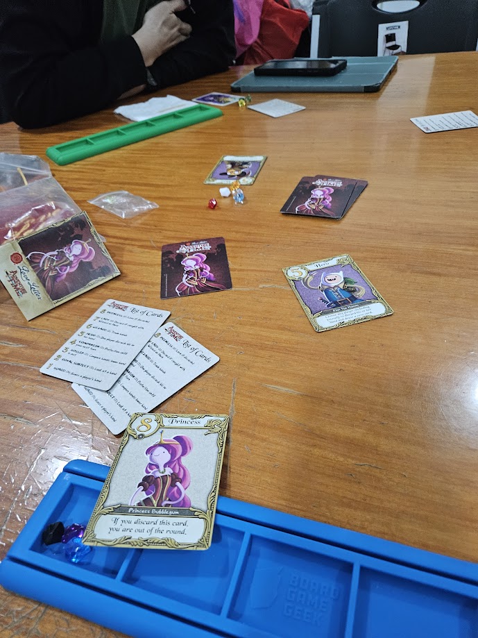 Gameplay photo of the board game Love Letter: Adventure Time featuring various components and board state.