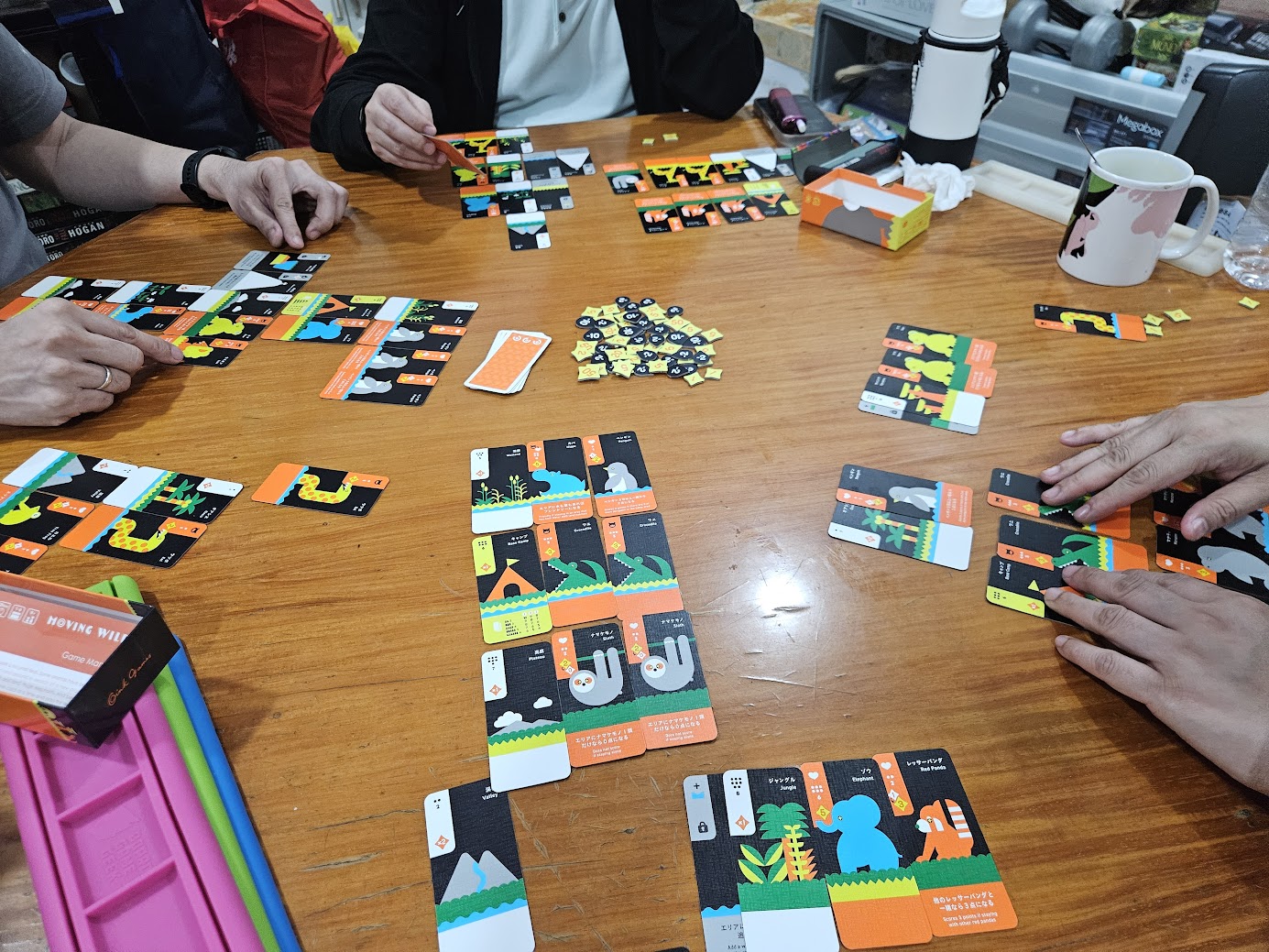 Gameplay photo of the board game Moving Wild featuring various components and board state.