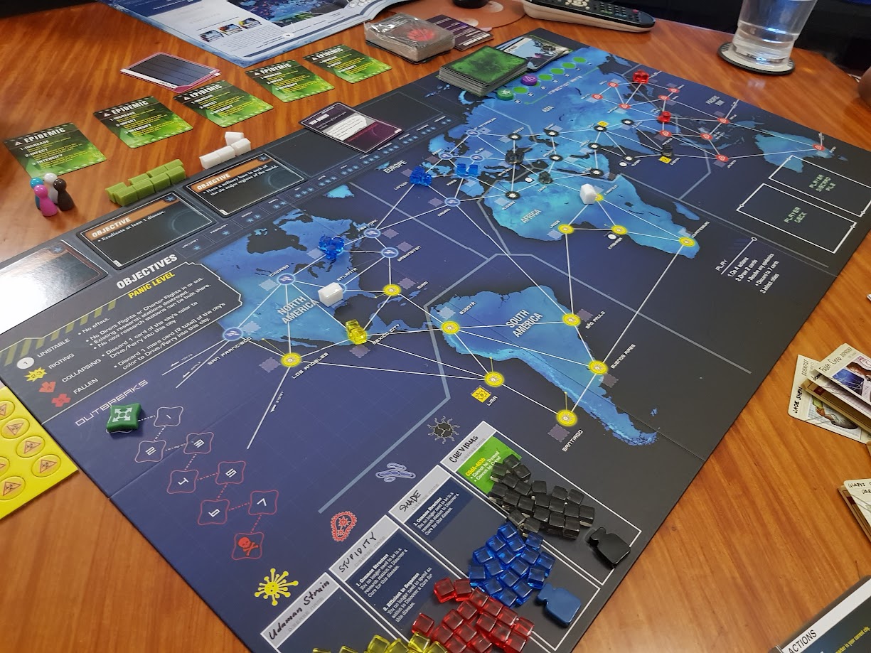 Gameplay photo of the board game Pandemic Legacy: Season 1 featuring various components and board state.