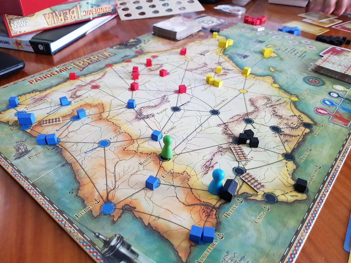Gameplay photo of the board game Pandemic: Iberia featuring various components and board state.