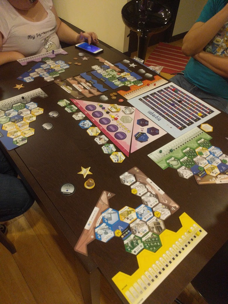 Gameplay photo of the board game Suburbia 5★ featuring various components and board state.
