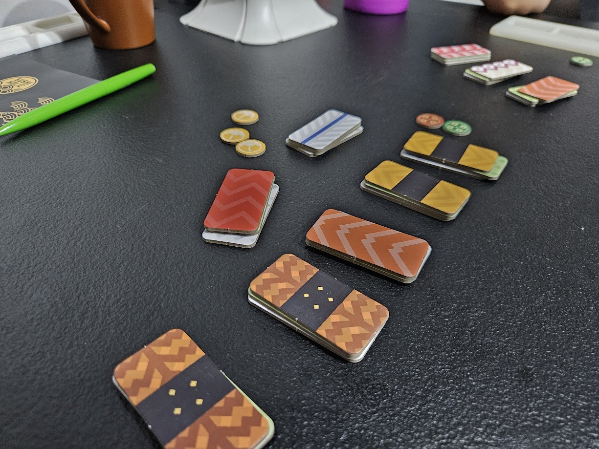 Gameplay photo of the board game Sushi Holic featuring various components and board state.