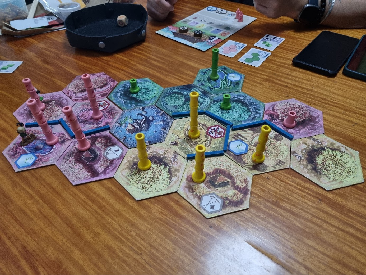 Gameplay photo of the board game Takenoko featuring various components and board state.