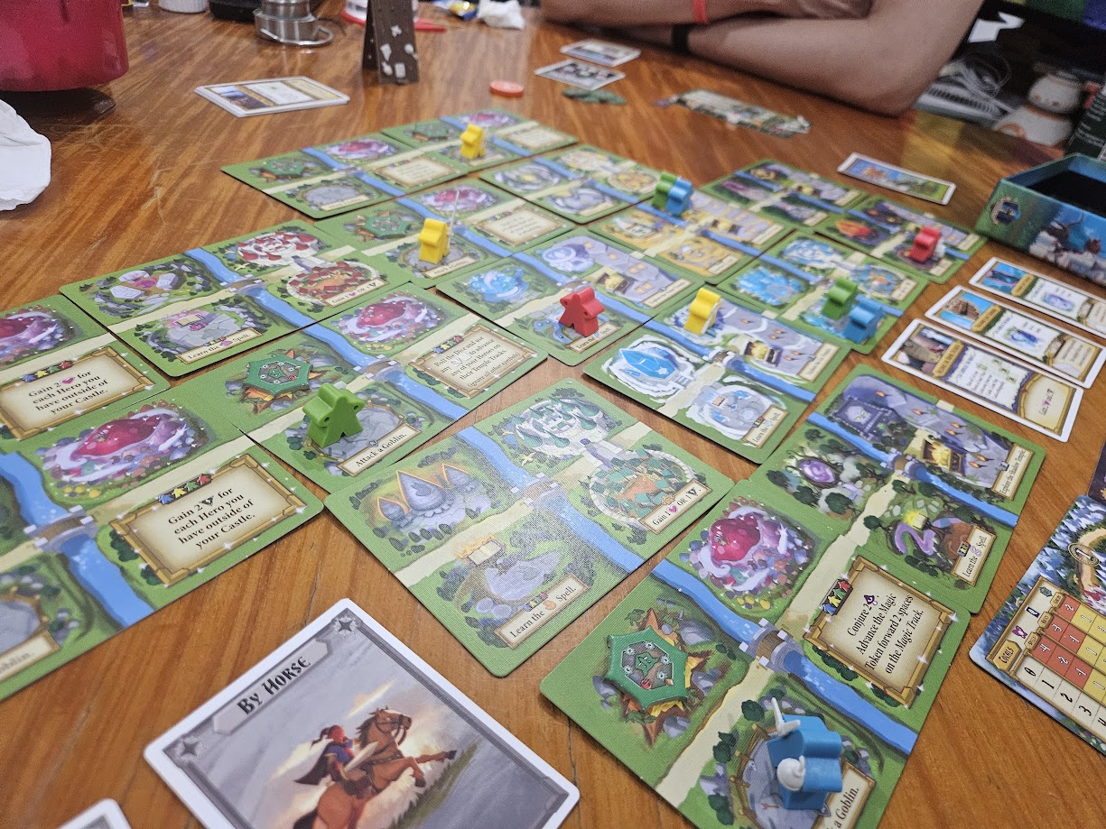 Gameplay photo of the board game Tiny Epic Quest featuring various components and board state.
