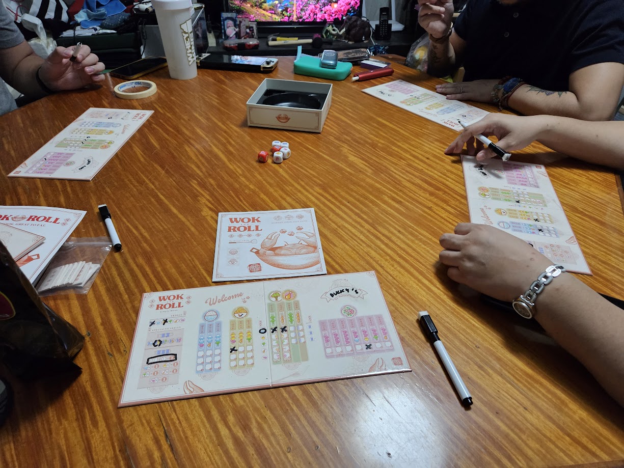 Gameplay photo of the board game Wok and Roll featuring various components and board state.