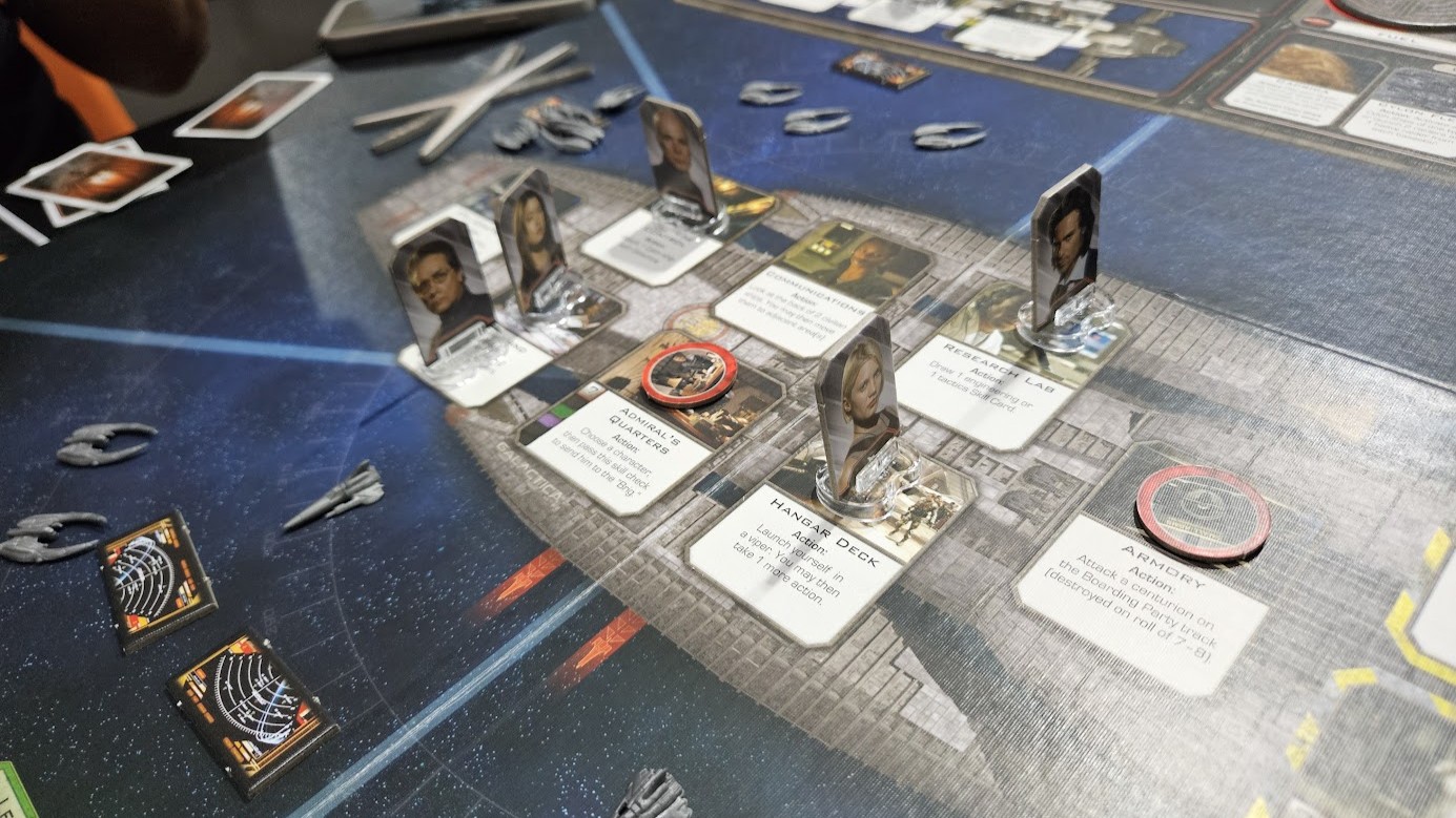 Gameplay photo of the board game Battlestar Galactica: The Board Game featuring various components and board state.