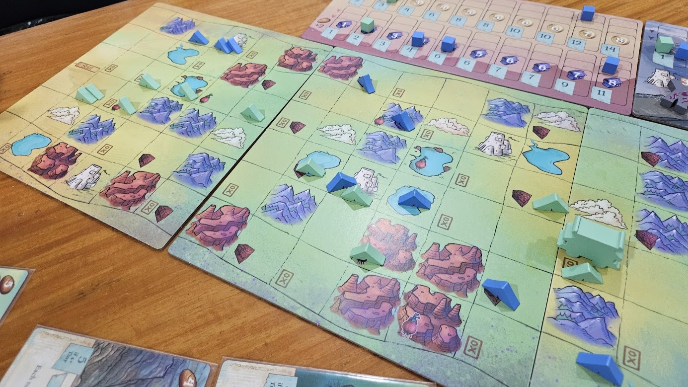 Gameplay photo of the board game Creature Caravan: Deluxe Edition featuring various components and board state.