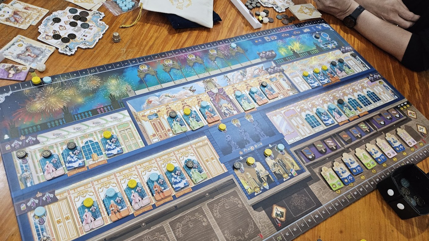 Gameplay photo of the board game Rococo: Deluxe Edition featuring various components and board state.