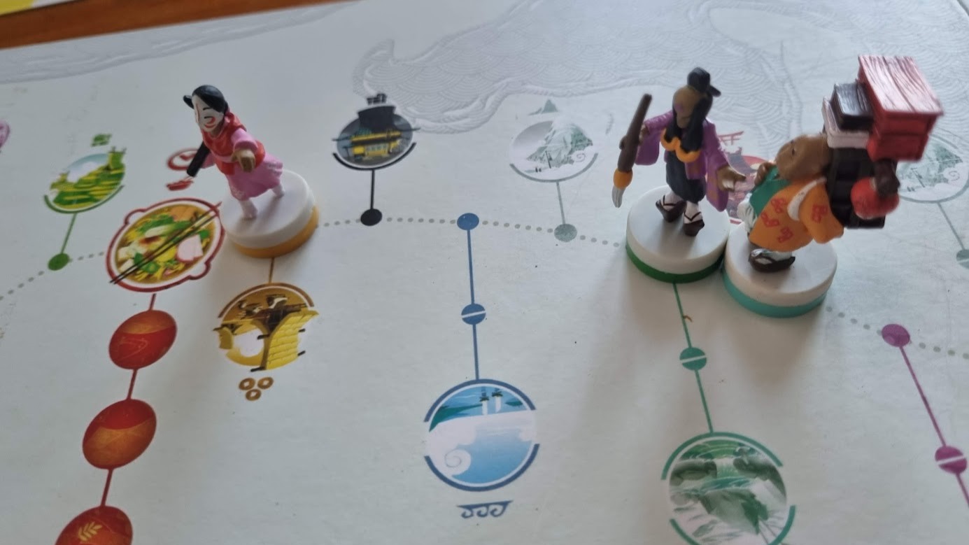 Gameplay photo of the board game Tokaido: Collector's Edition featuring various components and board state.