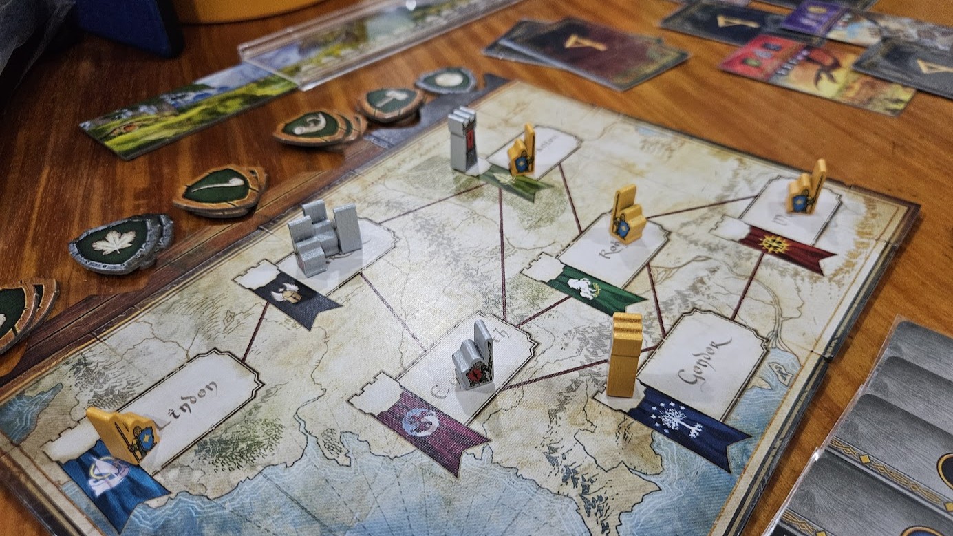 Gameplay photo of the board game The Lord of the Rings: Duel for Middle-earth featuring various components and board state.