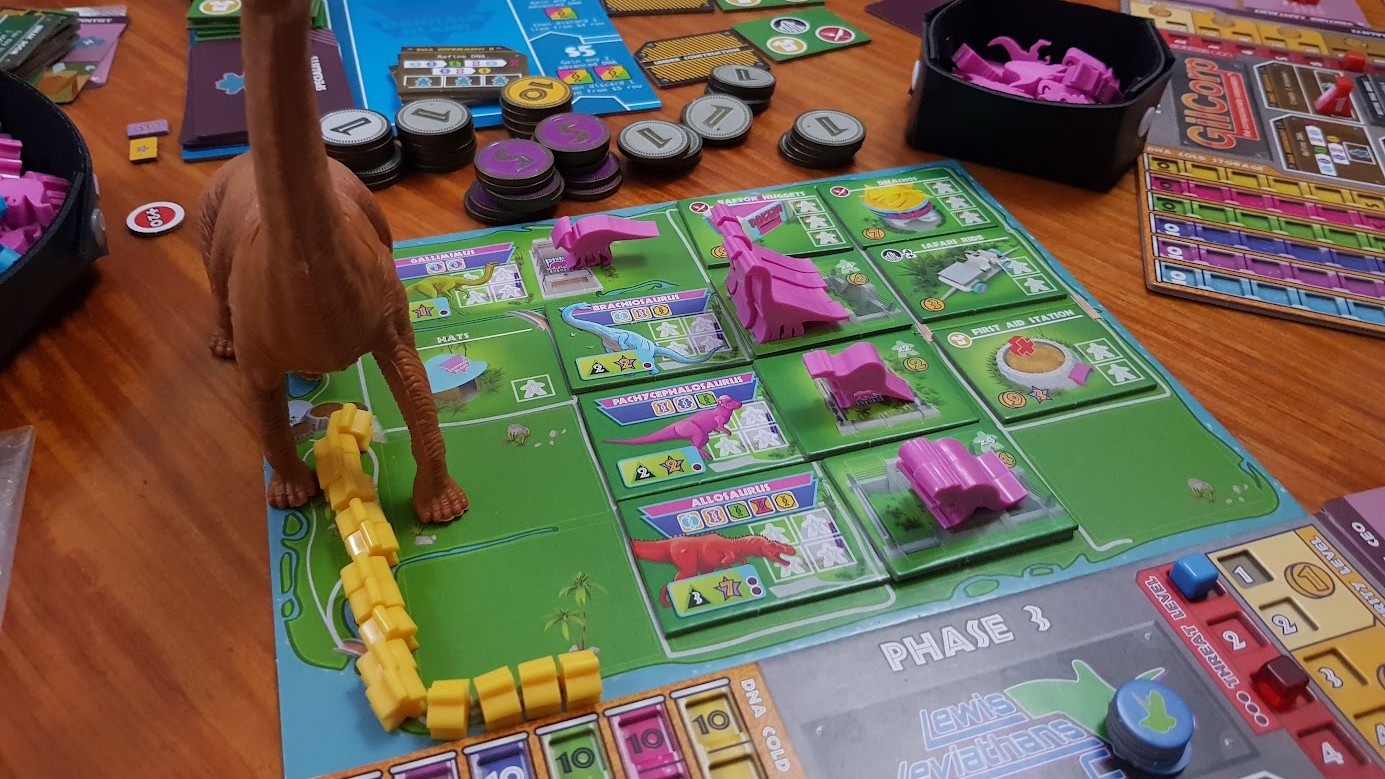 Gameplay photo of the board game Dinosaur Island: Totally Liquid featuring various components and board state.