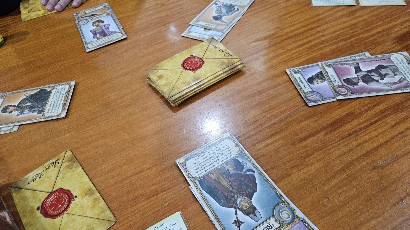 Gameplay photo of the board game Love Letter: Premium Edition featuring various components and board state.
