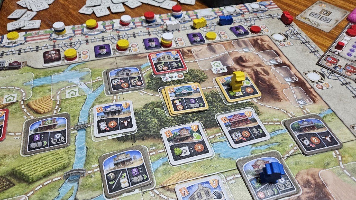 Gameplay photo of the board game Great Western Trail featuring various components and board state.