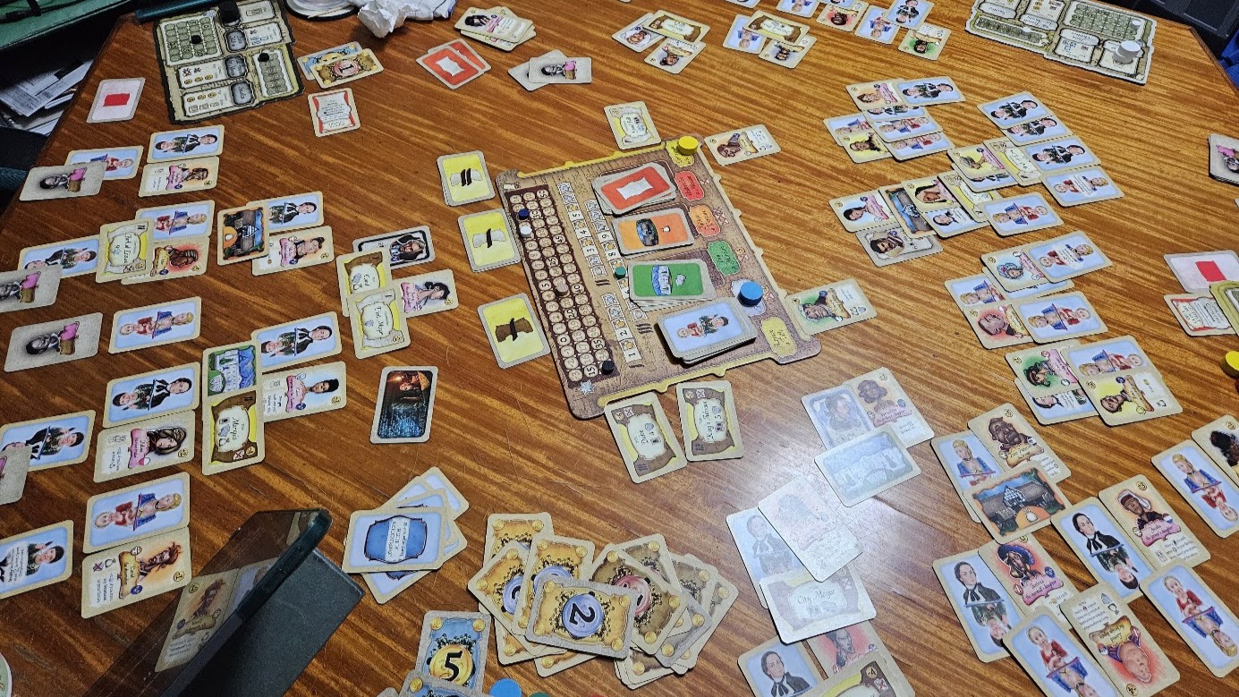 Gameplay photo of the board game Legacy: The Testament of Duke de Crecy featuring various components and board state.
