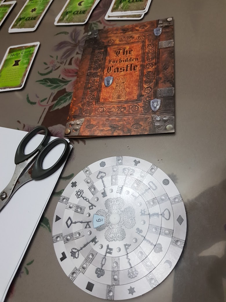 Gameplay photo of the board game EXIT: The Game – The Forbidden Castle featuring various components and board state.