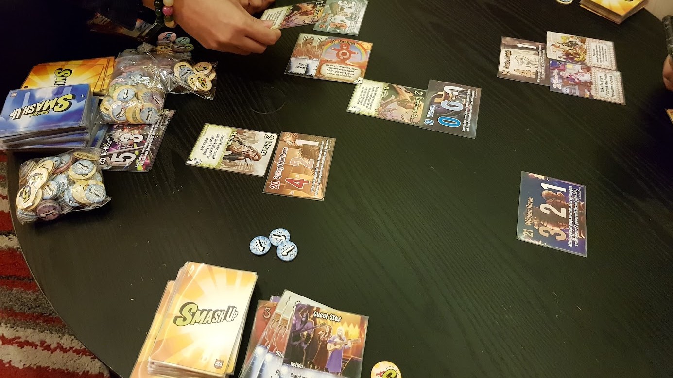 Gameplay photo of the board game Smash Up: What Were We Thinking? featuring various components and board state.